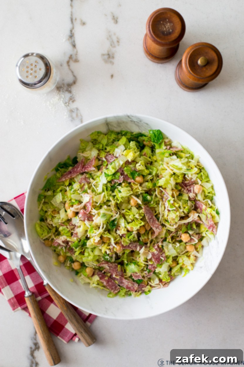 Overhead photo of a beautifully dressed La Scala Chopped Salad, ready to be enjoyed, in a simple white bowl