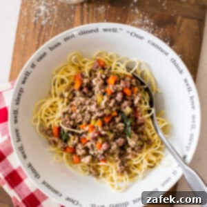 Bianco Bolognese 12 A mouth-watering image of White Bolognese served with pasta, garnished with fresh sage and grated Parmesan.