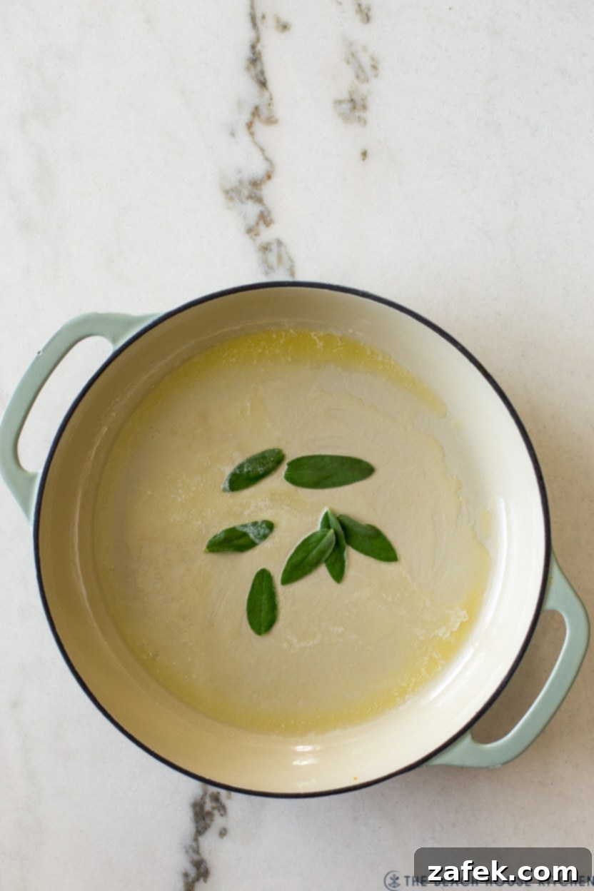 Bianco Bolognese 5 A close-up overhead shot of a skillet showing fresh sage leaves gently sizzling and crisping in melted butter, creating an aromatic start to the White Bolognese preparation.