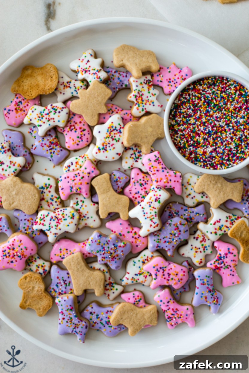 Overhead photo of a plate of colorful homemade animal cookies with a small bowl of nonpareils