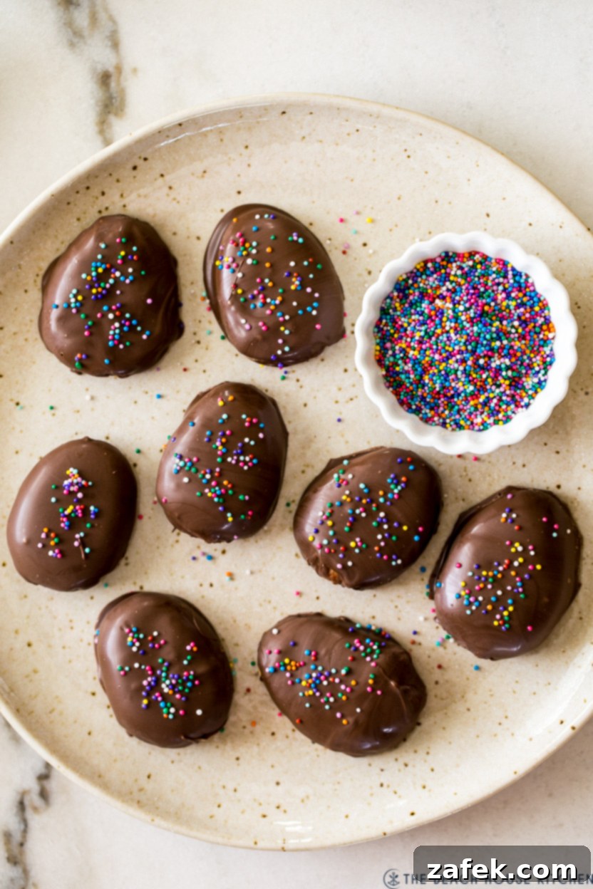 Irresistible Peanut Butter Eggs from Scratch 2 Overhead photo of a plate of chocolate covered peanut butter eggs with a small bowl of nonpareils