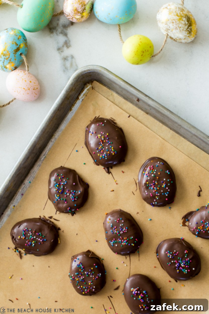 Irresistible Peanut Butter Eggs from Scratch 7 Chocolate covered peanut butter eggs on a parchment-lined baking sheet