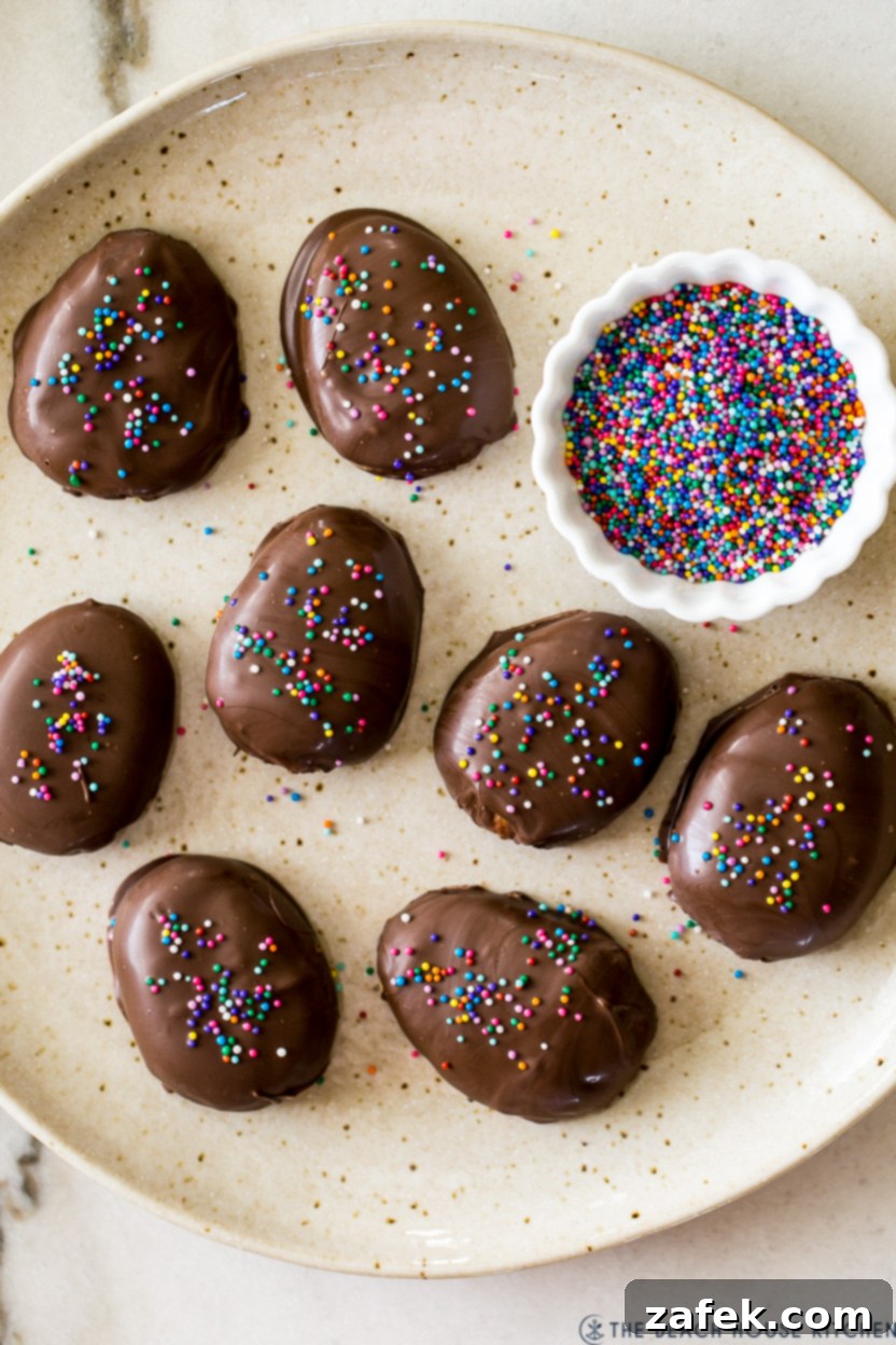 Irresistible Peanut Butter Eggs from Scratch 8 Up close overhead photo of a plate of homemade peanut butter eggs with a small bowl of nonpareils