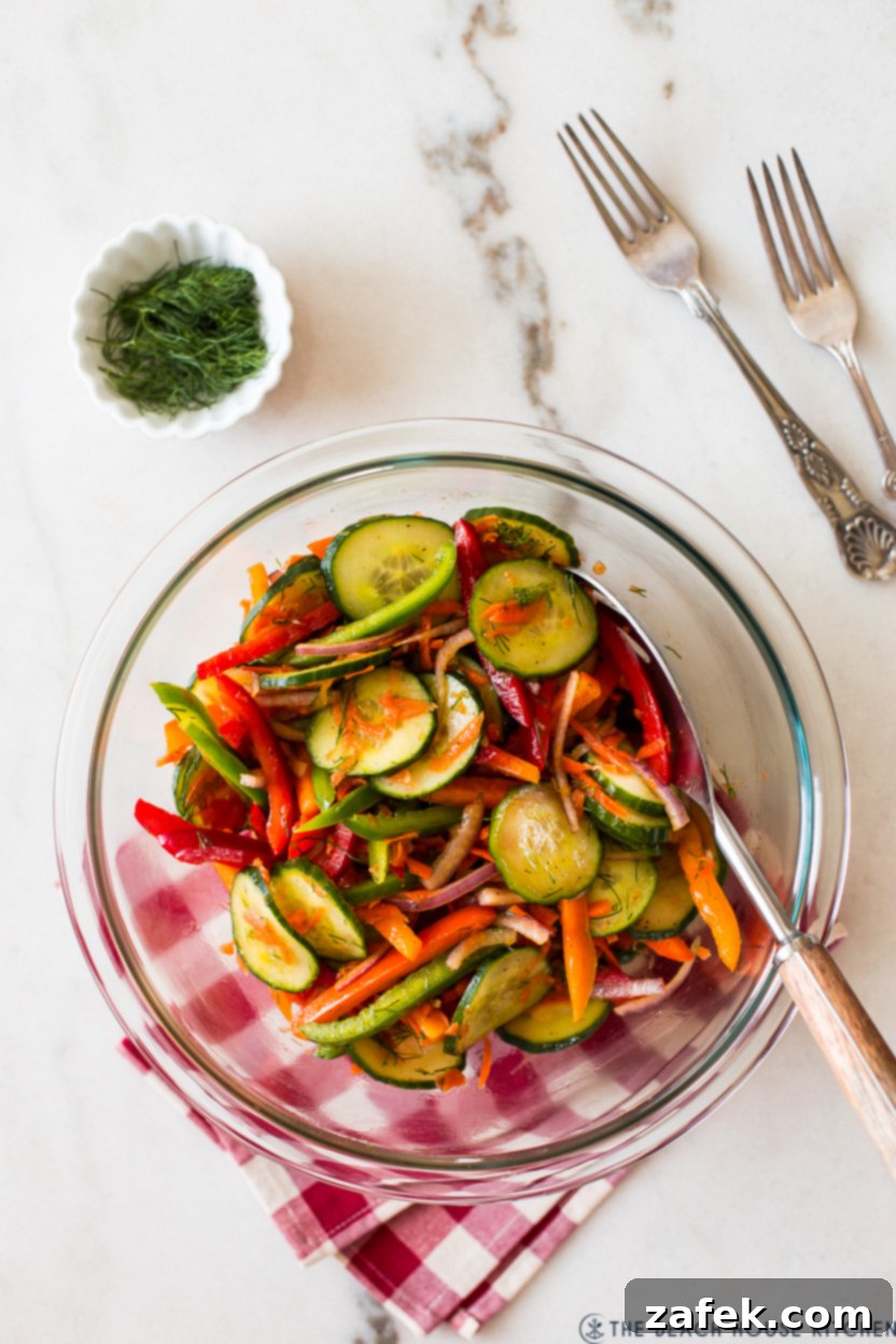 Overhead photo of the finished Easy Cucumber Salad served in an elegant glass bowl, ready to be enjoyed.