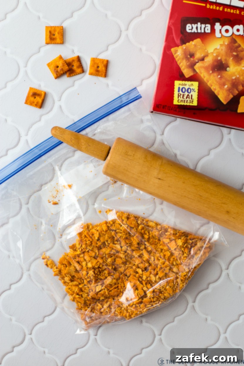 Cheez-Its being crushed in a Ziploc bag with a rolling pin.