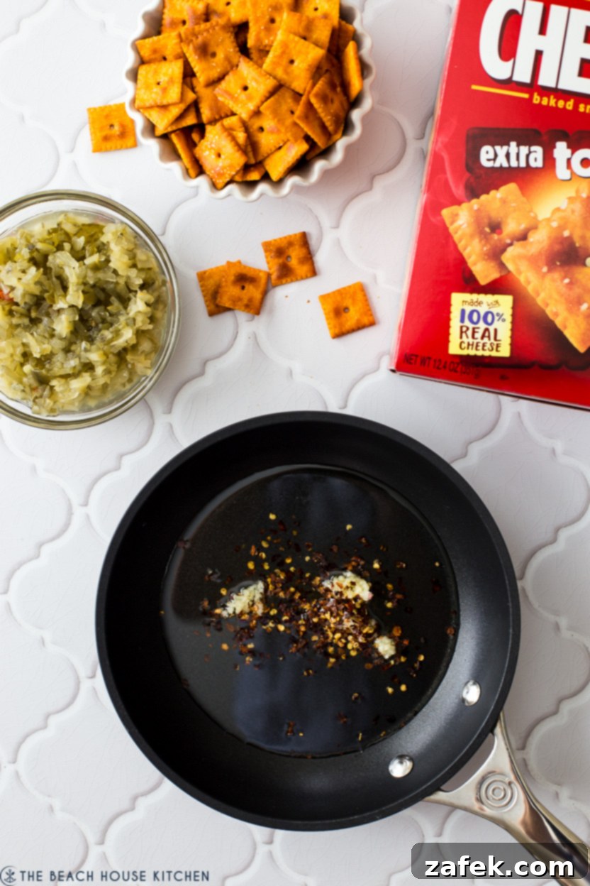 Garlic and red pepper flakes sizzling in vegetable oil in a small skillet.