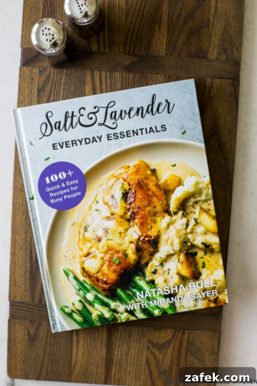 Hot Wing Soup 3 Overhead photo of the Salt & Lavender Everyday Essentials Cookbook, beautifully displayed on a rustic wooden board, hinting at the culinary treasures within its pages.