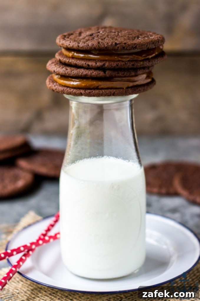 Mexican Chocolate Sandwich Cookies with Dulce de Leche Filling artfully stacked on a milk bottle, showcasing their rich texture