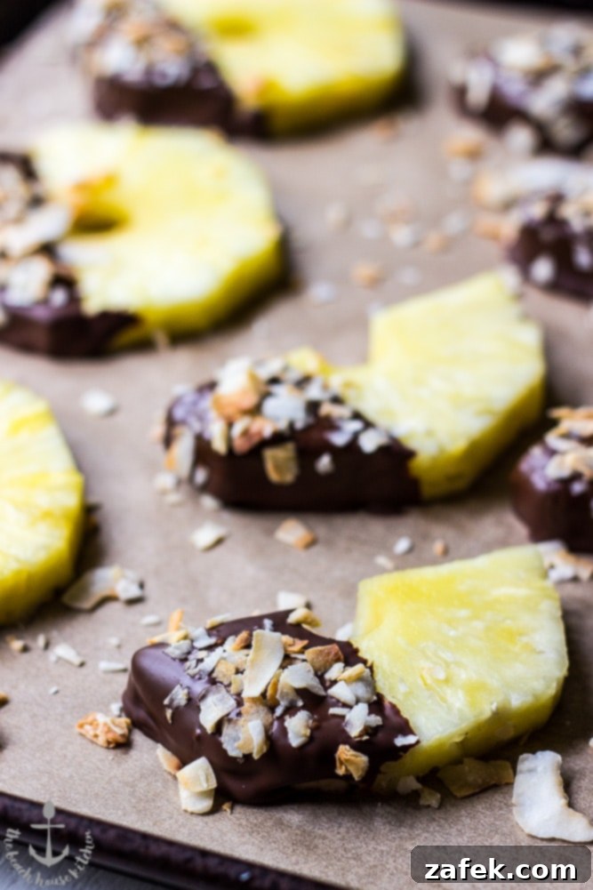 Toasted Coconut Pineapple Chocolate Treats 4 An array of delicious chocolate-dipped pineapple slices with toasted coconut, ready to be enjoyed as a refreshing dessert.