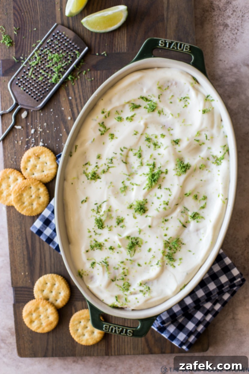 Up close overhead photo of a key lime cracker pie in an oval dish, showcasing its creamy layers and cracker base