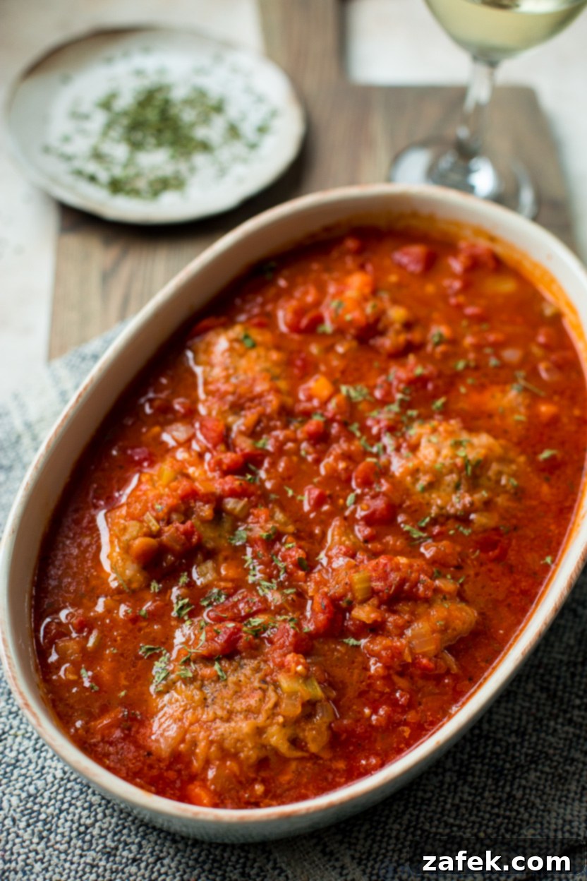 Rustic Braised Chicken with Root Vegetables 5 Up close photo of a baking dish of chicken osso buco