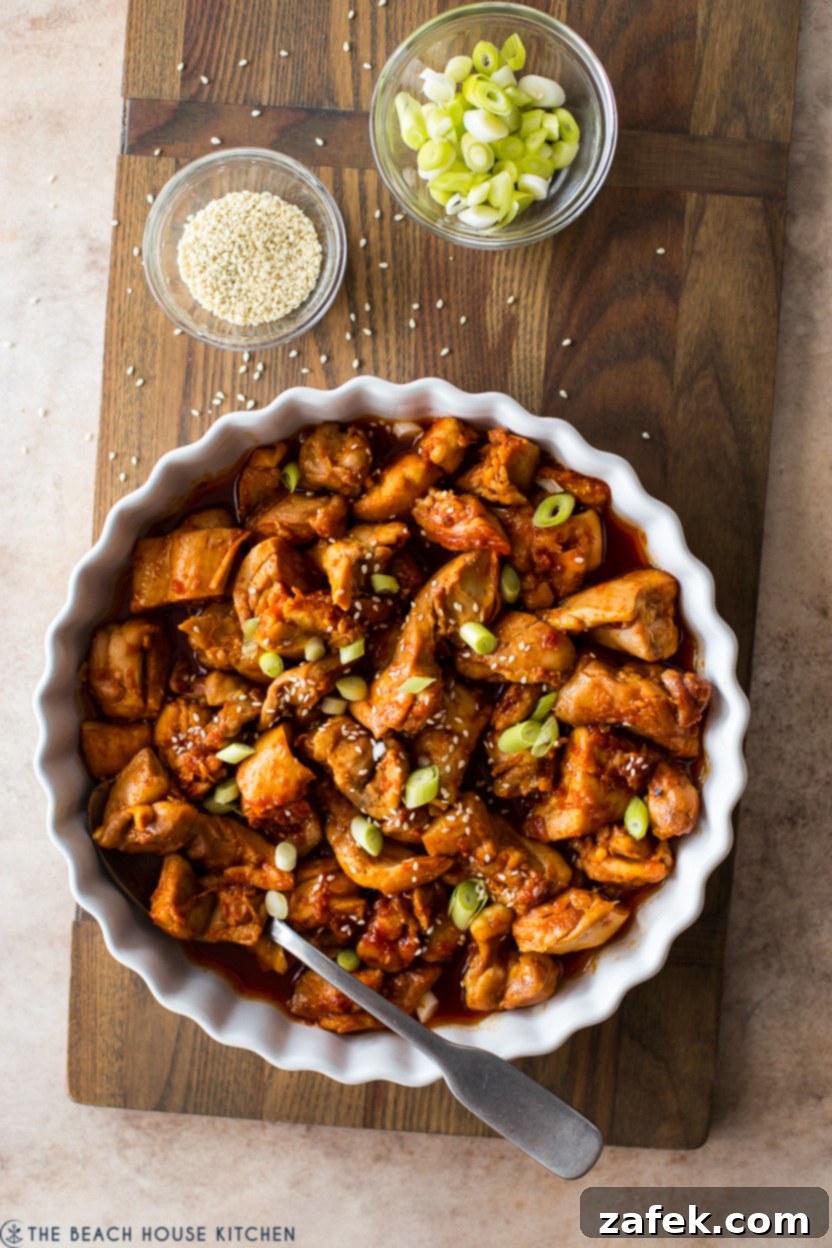 Crispy Gochujang Chicken Stir-Fry 3 Overhead photo of Stir-Fried Gochujang Chicken in a round baking dish, showcasing its glossy sauce and garnished finish.