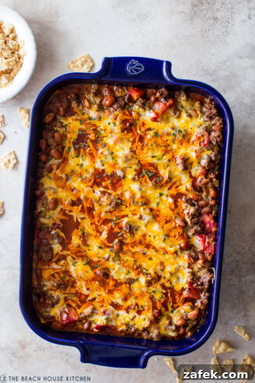 Overhead photo of a beef enchilada casserole in a blue baking dish