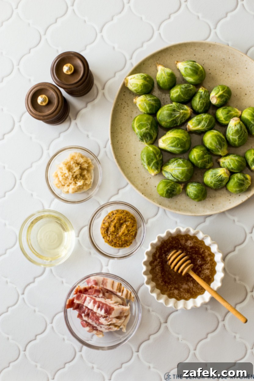 Overhead photo of the simple, yet impactful ingredients for Roasted Brussels Sprouts with Horseradish-Honey Mustard Glaze: fresh Brussels sprouts, olive oil, honey, horseradish, coarse-grain mustard, and raw bacon slices.