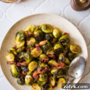 A beautifully plated serving of Roasted Brussels Sprouts with Horseradish-Honey Mustard Glaze and crispy bacon bits.