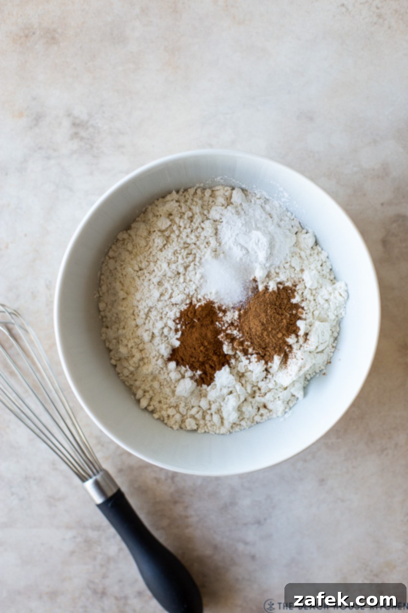 Autumn Spiced Pumpkin Madeleines 5 An overhead photo of a bowl filled with perfectly mixed flour and aromatic spices, ready for the next step of baking Pumpkin Madeleines, with a whisk resting nearby.