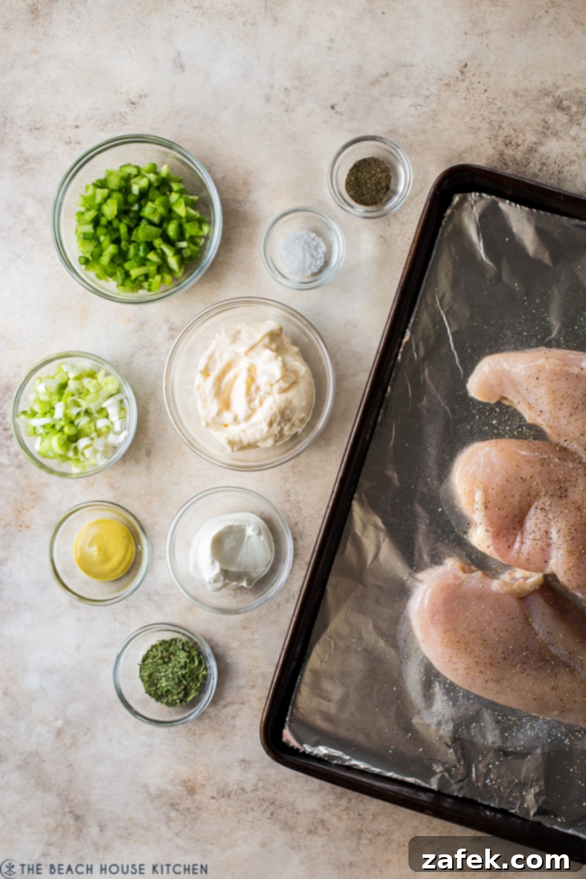 Overhead photo of fresh ingredients for classic chicken salad laid out on a wooden board.