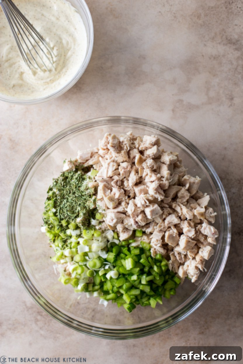 Overhead photo of a bowl with pre-mixed chicken salad ingredients before the dressing is added.