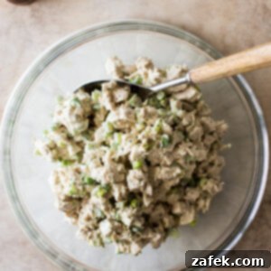 A classic chicken salad ready to be served, in a round white bowl.