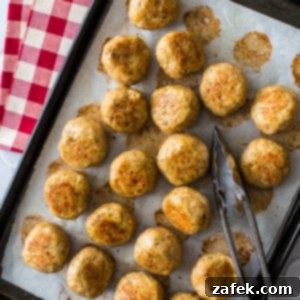 A perfectly baked chicken meatball, showcasing its golden-brown exterior and tender texture, ready to be enjoyed.