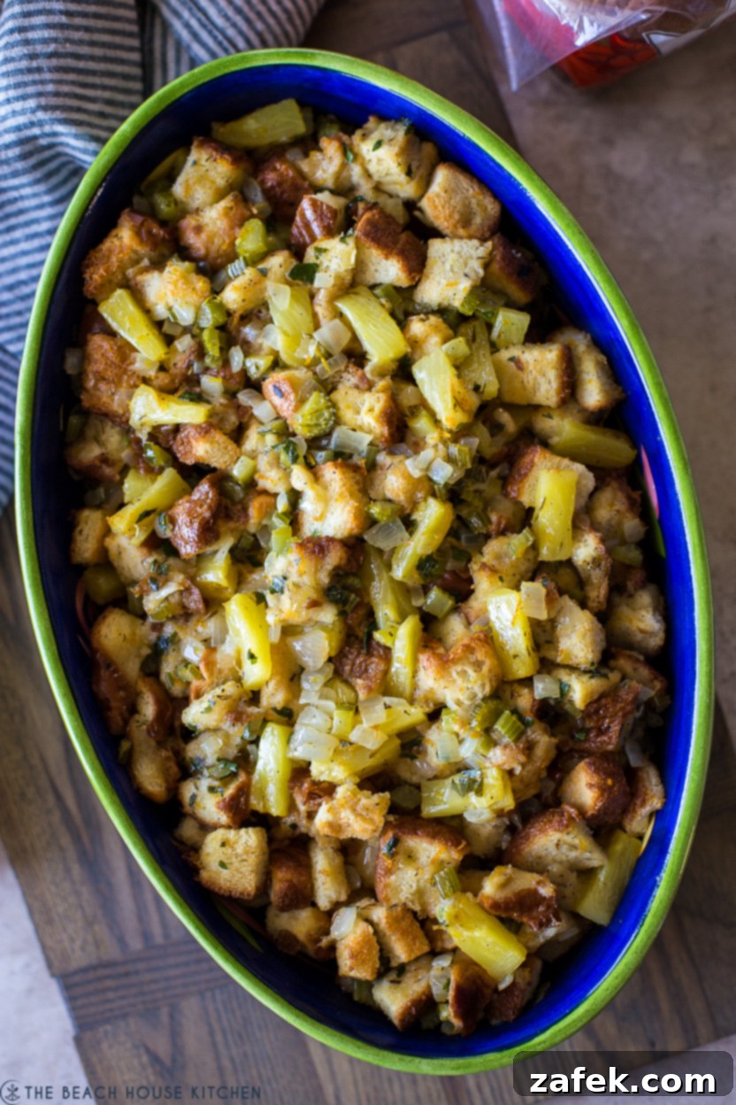 Golden Pineapple Stuffing 3 Up close overhead photo of an oval dish of pineapple stuffing, showing the golden crust, soft interior, and visible pineapple pieces