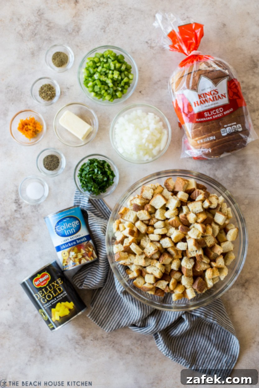 Golden Pineapple Stuffing 4 Overhead photo of all the raw ingredients for pineapple stuffing laid out: Hawaiian bread, butter, celery, yellow onion, chicken broth, dried herbs, salt, pepper, pineapple tidbits, fresh parsley, and orange