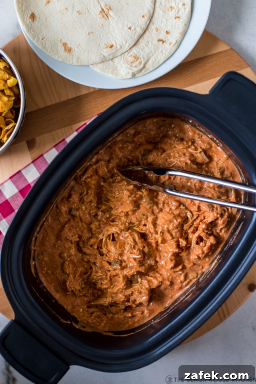 Overhead photo of a slow cooker filled with Creamy Taco Chicken, simmering to perfection.