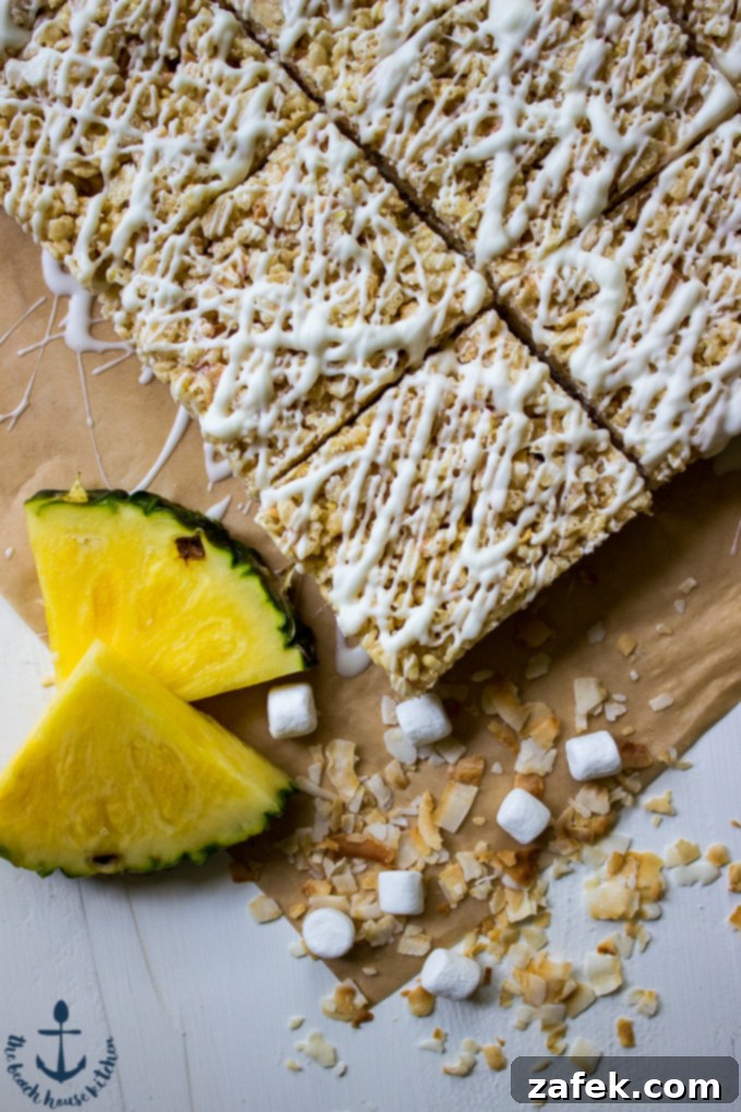 A stack of perfectly cut Tropical Rice Krispy Treats with a generous white chocolate drizzle