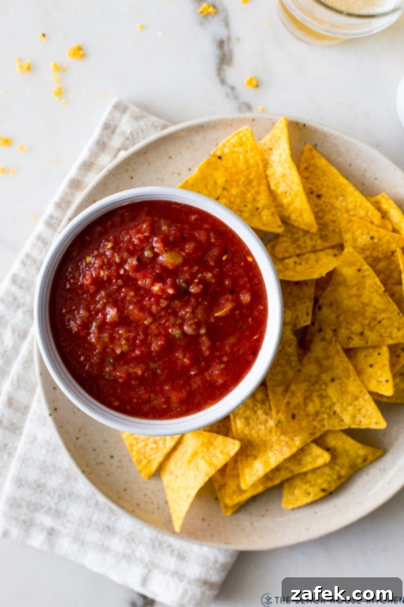 Overhead photo of a bowl of restaurant style salsa on a plate with tortilla chips