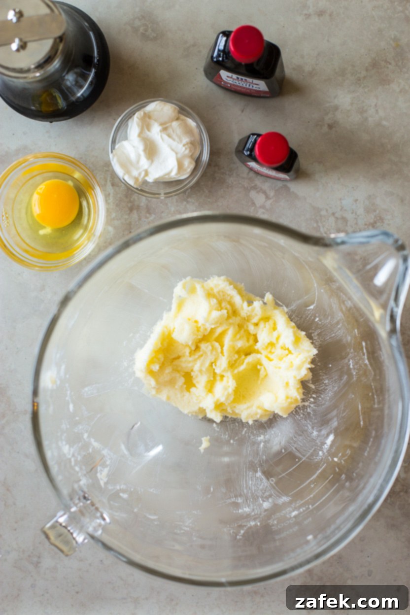 Sweet Maple Blueberry Pancake Muffins 7 Overhead photo of a mixing bowl containing a creamy, light yellow mixture of butter and sugar, indicating it's well creamed