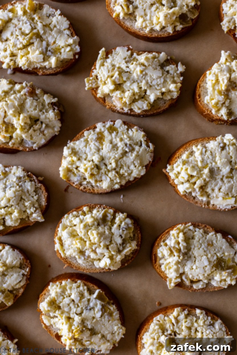 Whispers of Josephina 7 Overhead photo of baguette slices topped with the Josephinas cheese mixture, ready for broiling.