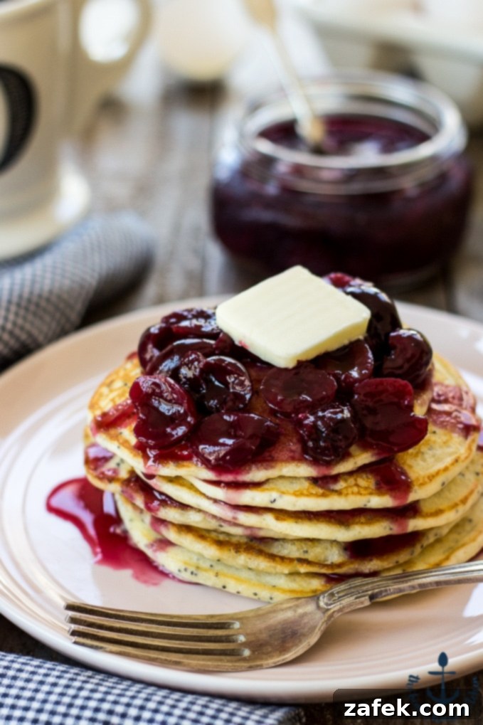 Zesty Lemon Poppy Seed Pancakes with Ruby Cherry Compote 5 An inviting close-up of a Lemon Poppyseed Pancake with Cherry Compote, ready to be enjoyed as a delightful summer treat.