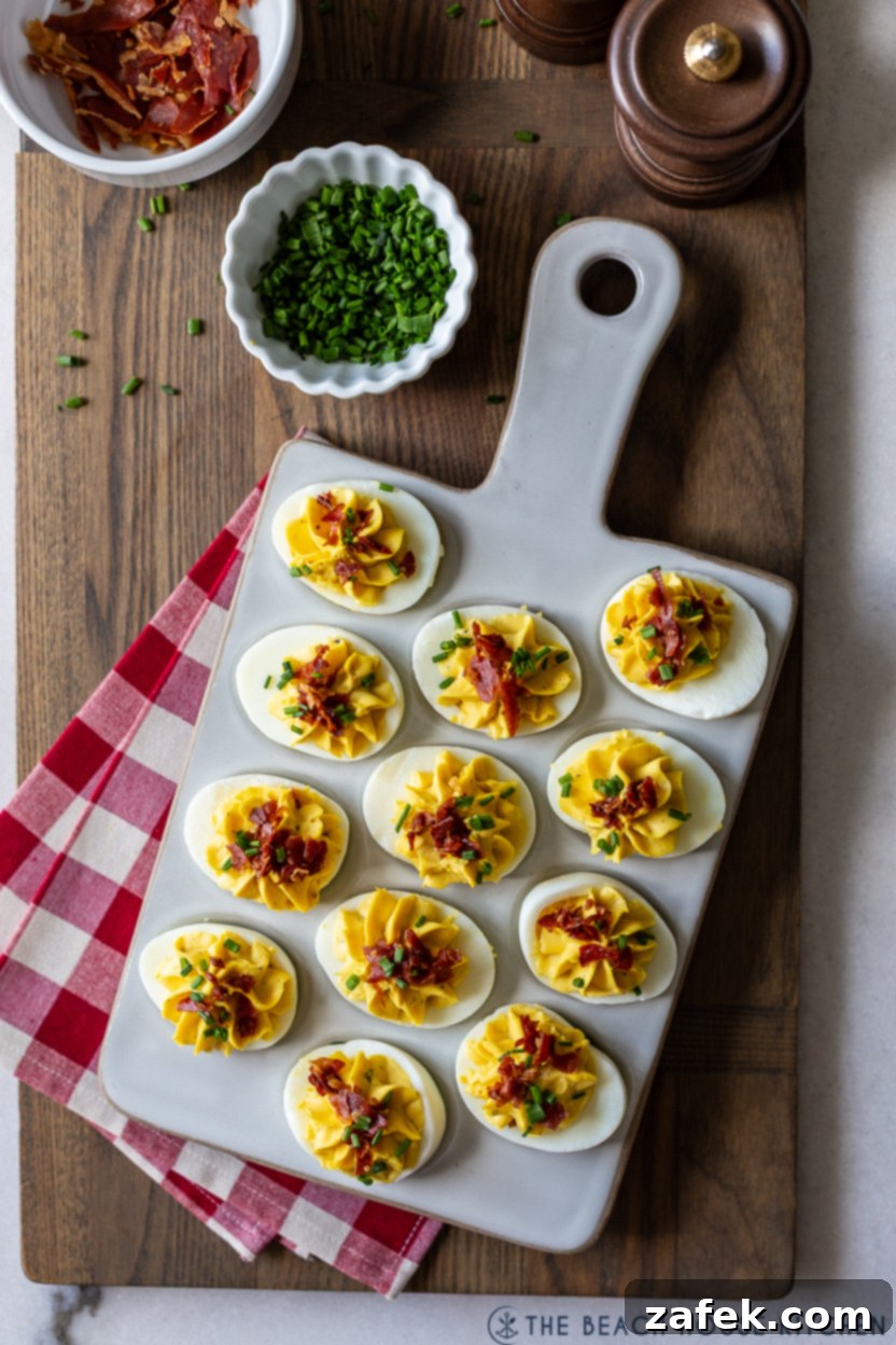Overhead photo showcasing a platter of green-tinged wasabi deviled eggs, each garnished with a generous sprinkle of crispy proscuitto