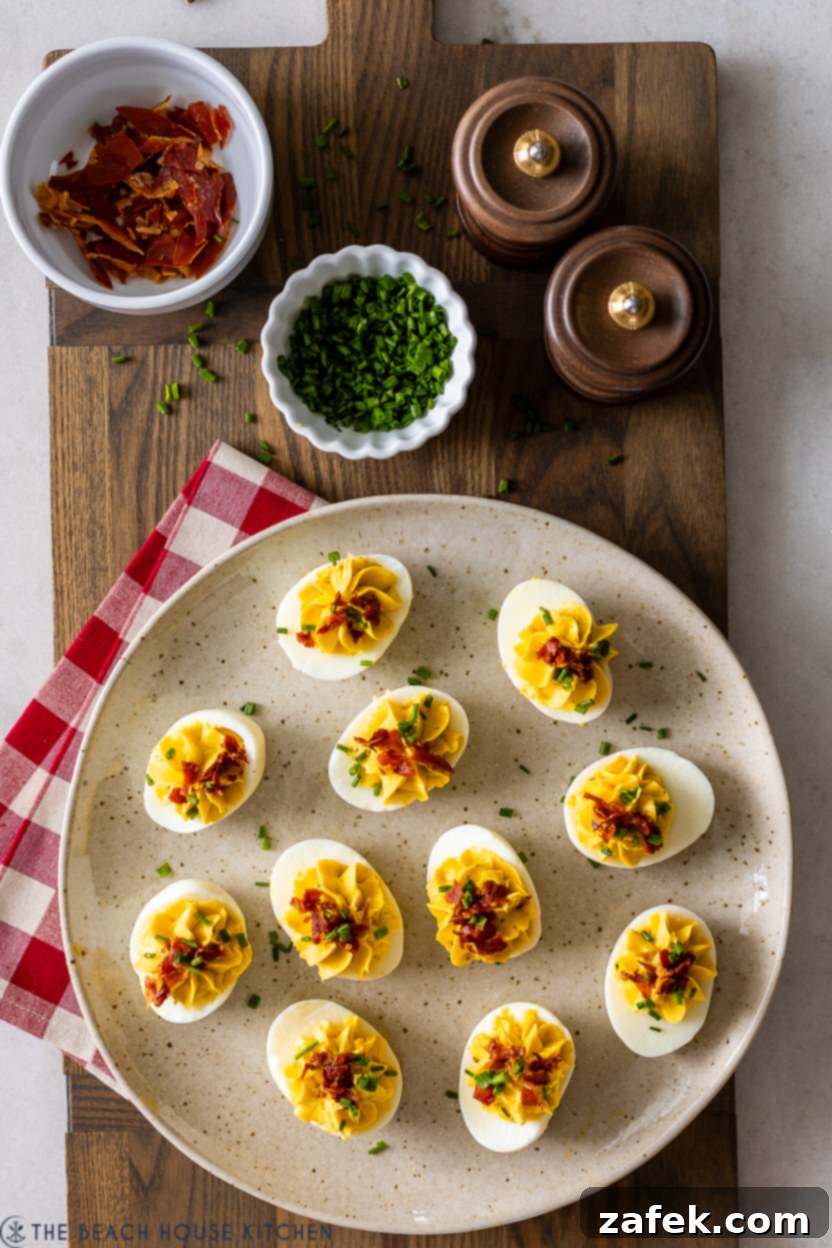 Close-up overhead photo of a plate of Wasabi Deviled Eggs with Crispy Prosciutto, showcasing the vibrant green filling and crunchy topping
