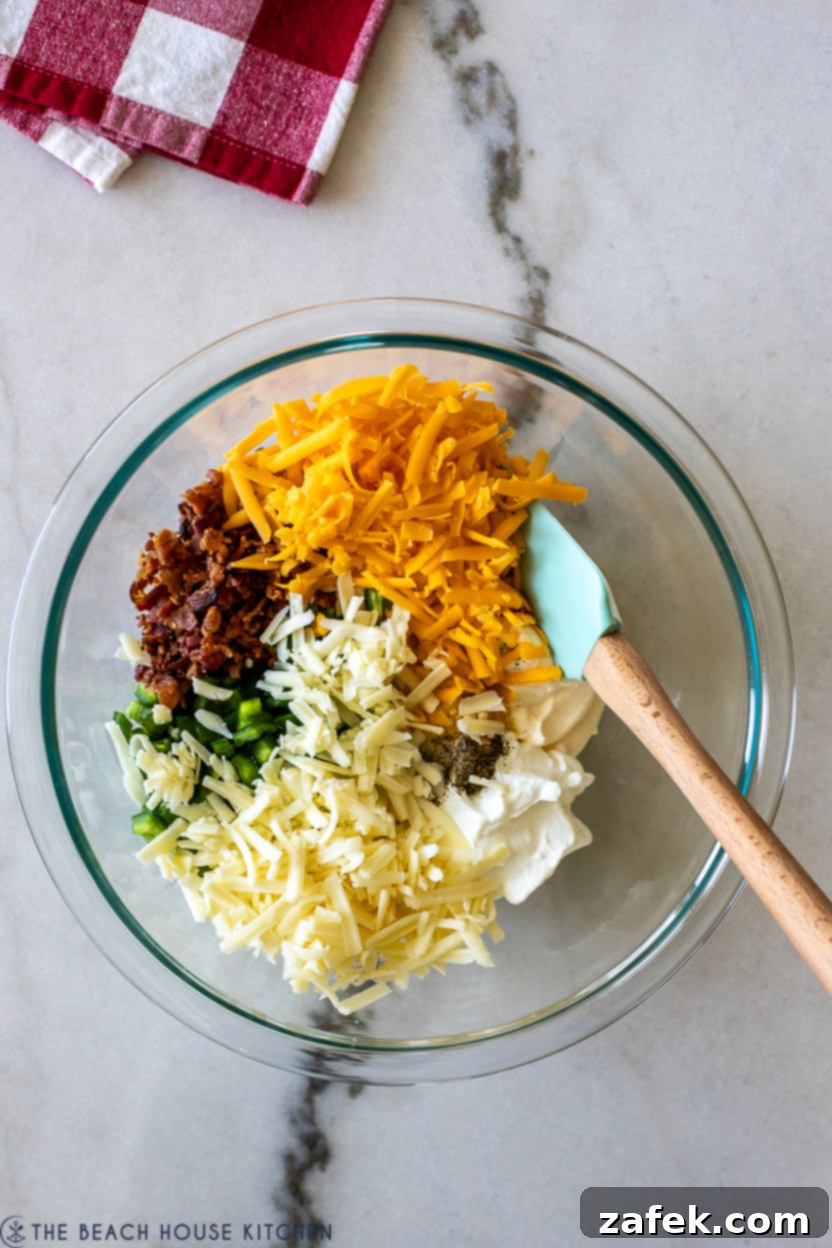 Loaded Jalapeño Popper Dip 5 Overhead photo of ingredients for jalapeno dip in a bowl with a spatula