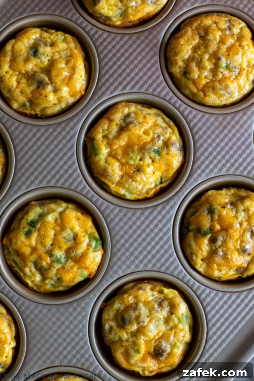 Up close overhead photo showcasing the fluffy texture and savory fillings of baked sausage egg and cheese breakfast muffins.