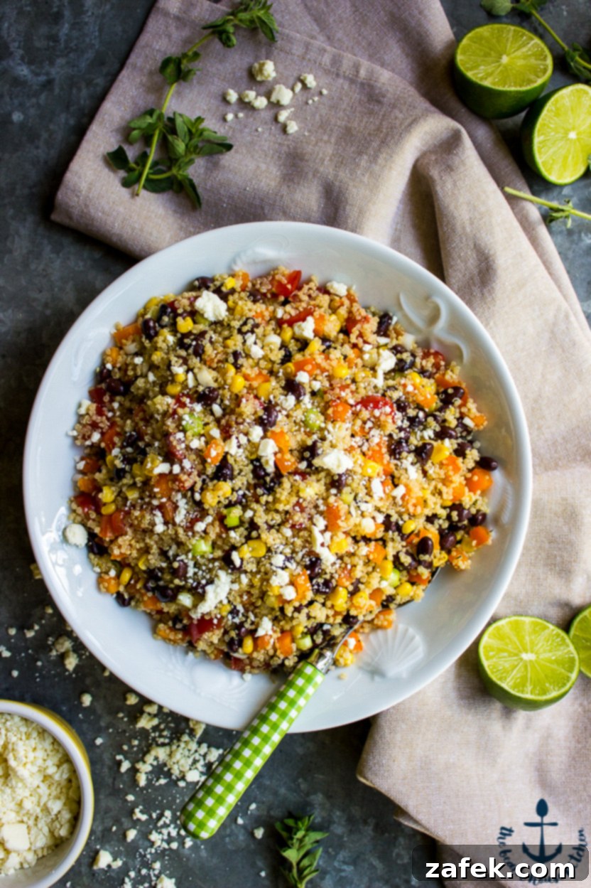 Vibrant Southwest Quinoa Salad with Tangy Lime and Cotija 2 Overhead photo of a vibrant Southwestern Quinoa Salad in a white bowl, garnished with fresh cilantro and lime wedges.