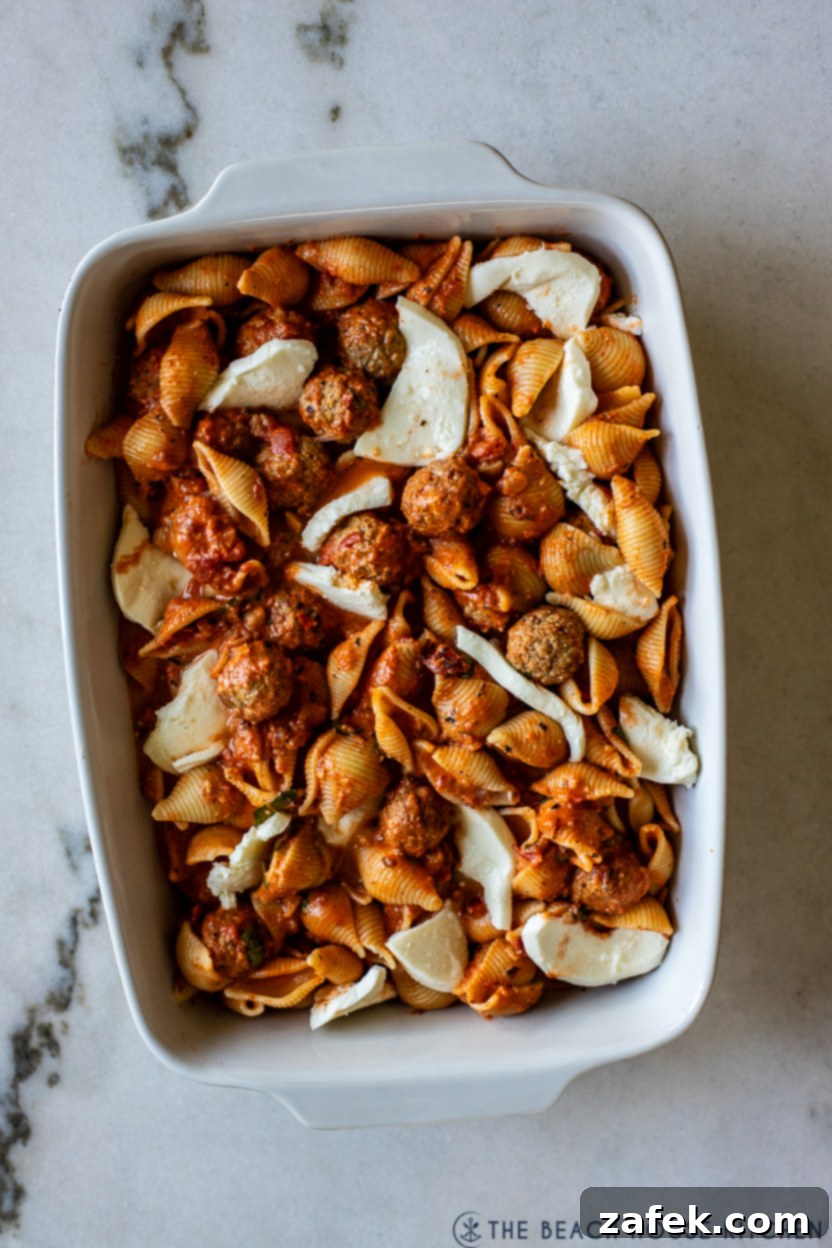 Assembling the Meatball Pasta Bake in a baking dish before oven
