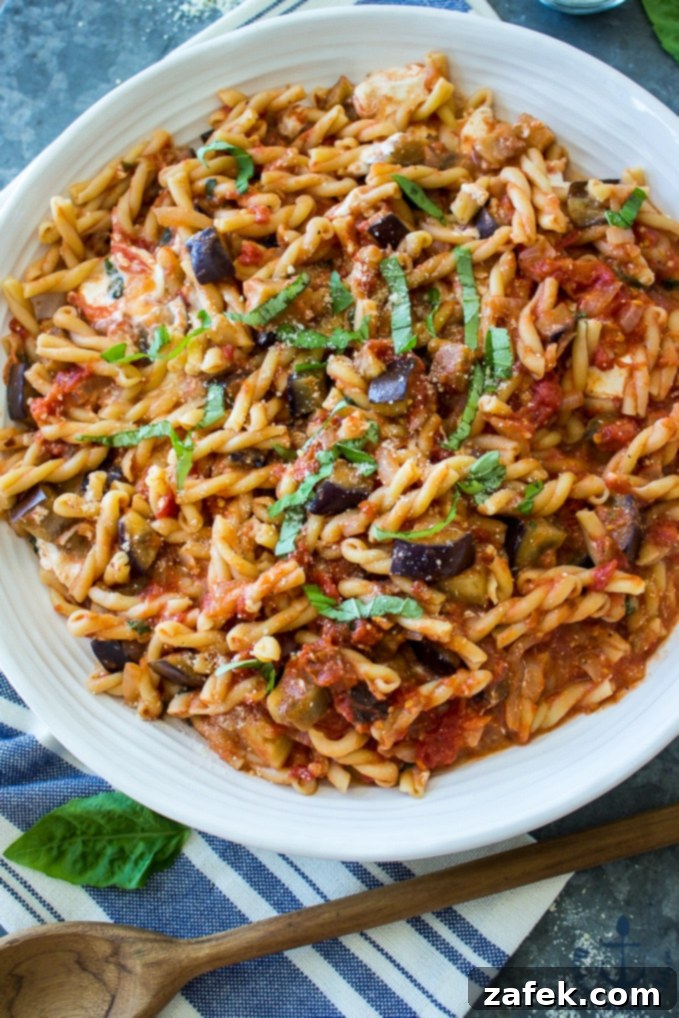 Sweet and Savory Burrata Pasta with Eggplant and Caramelized Onion 5 Bowl of Eggplant, Caramelized Onion, Tomato and Burrata Pasta with a fork taking a bite