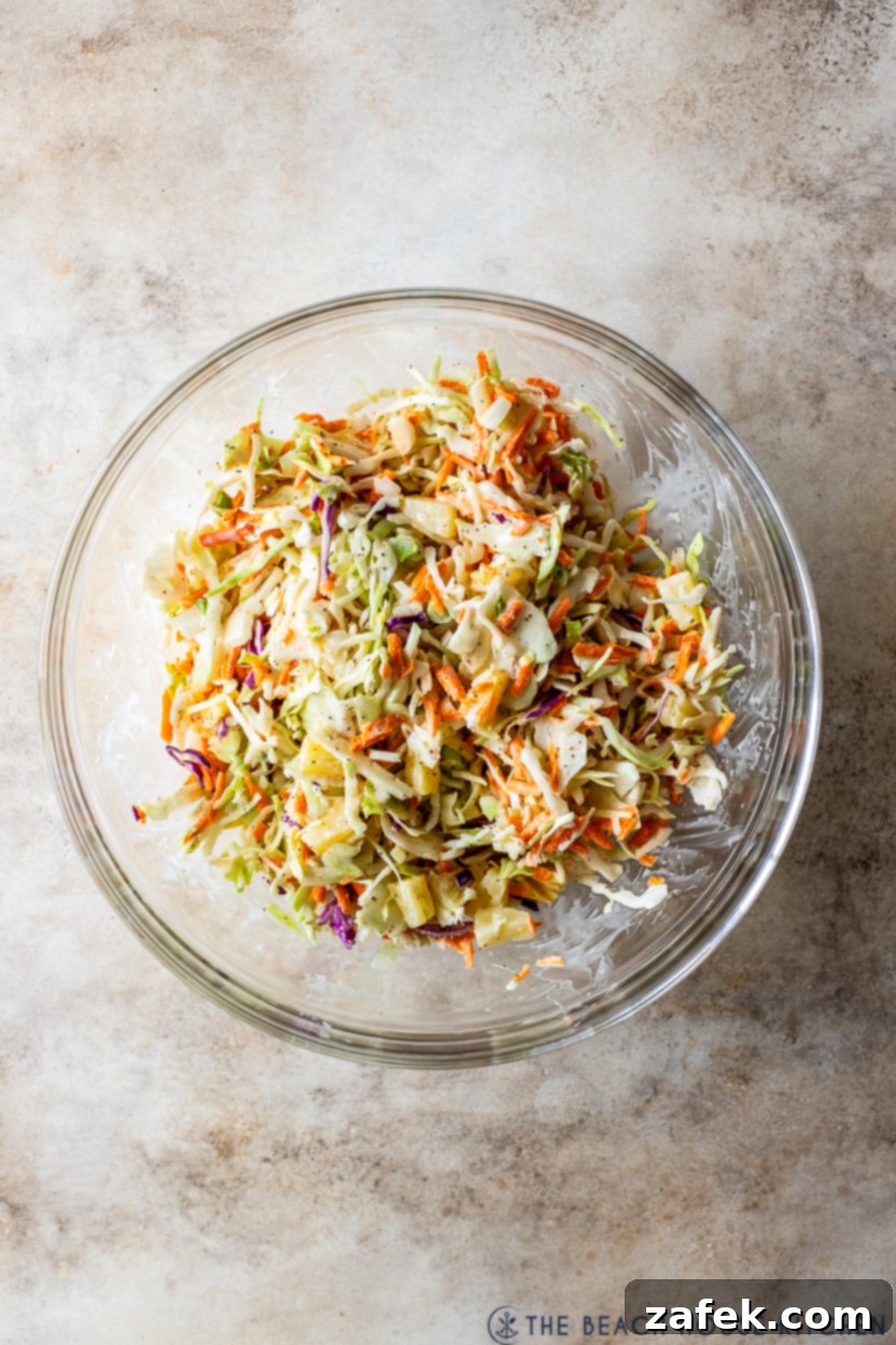 Overhead photo of a glass bowl of pineapple coleslaw ready to be served