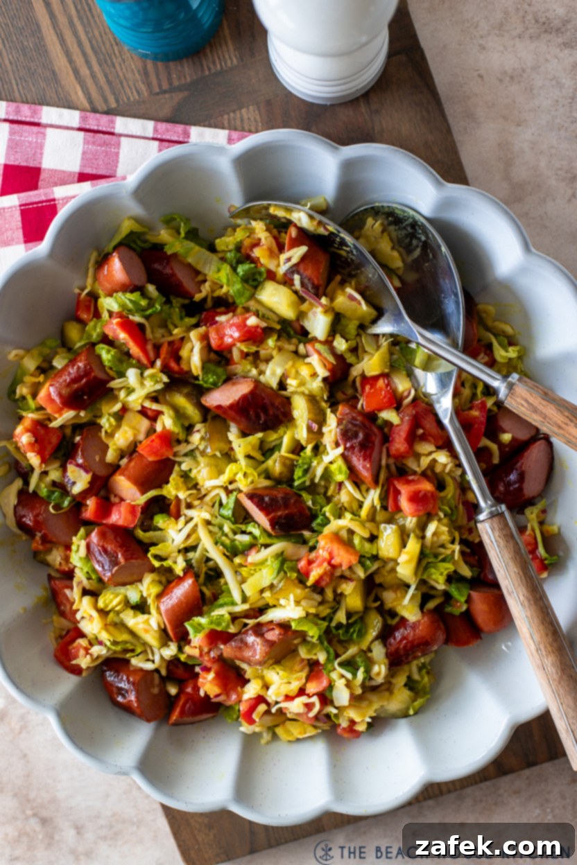 Up close overhead photo of a white scalloped serving dish filled with a vibrant Chicago Hot Dog Salad, showcasing its colorful ingredients and ready for summer gatherings.