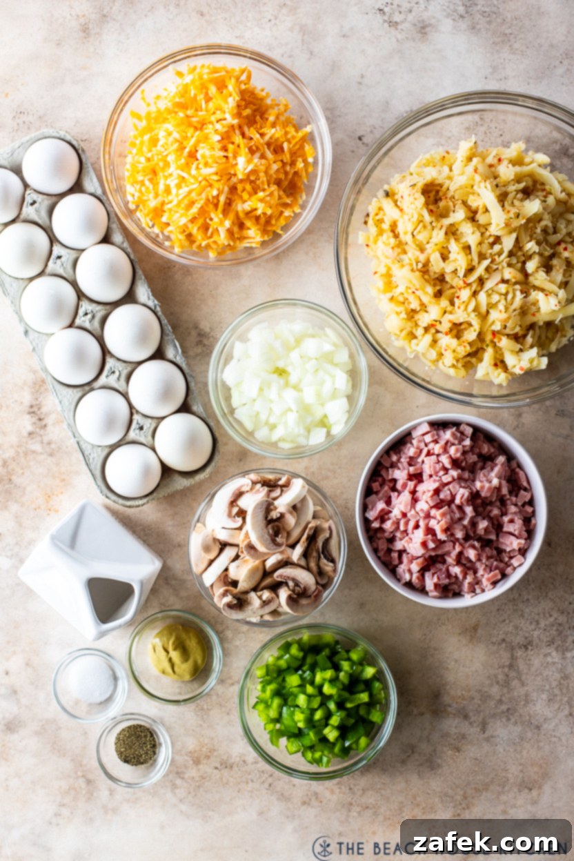Golden Ham and Veggie Hash Brown Bake 4 Overhead photo of all the fresh ingredients laid out for making the ham and vegetable hash brown breakfast casserole: eggs, ham, hash browns, cheese, mushrooms, onions, and green peppers.