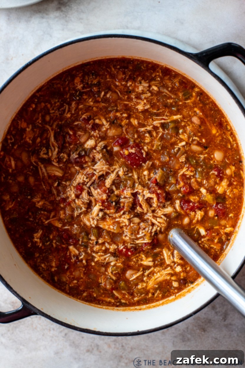 Up close overhead photo of a pot of buffalo chicken chili, showcasing its rich texture and color