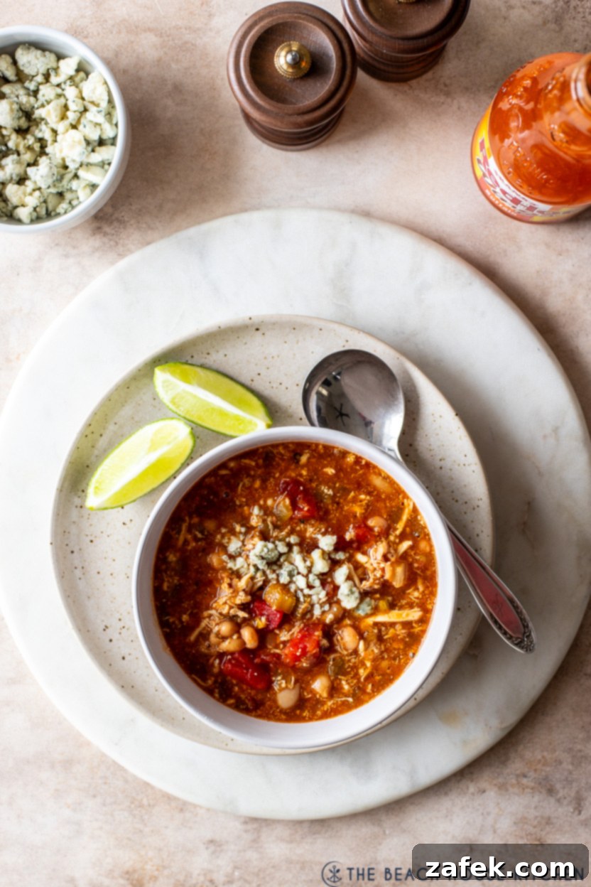 Overhead photo of a bowl of buffalo chicken chili topped with blue cheese crumbles, ready to eat
