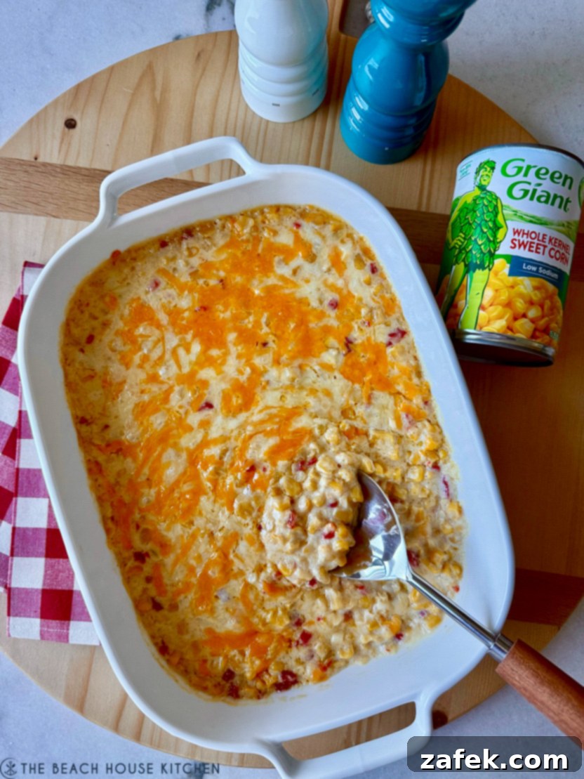 Overhead photo of a casserole dish of pimento cheese creamy corn, showing its creamy texture and cheesy topping.